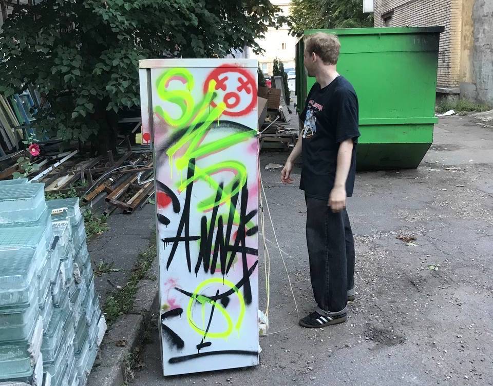 The fridge is covered in graffiti